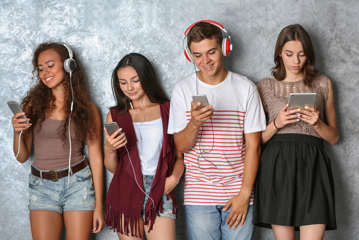 Young People with Gadgets on Grey Background